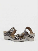 Leopard print two-strap wedge sandals showing strap detail and cushioned footbed, angled view on white background.