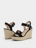 Black espadrille wedge sandals showing open-toe design and natural jute rope wedge sole, angled view.