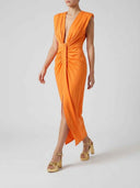 Orange midi dress with deep V-neck, ruched bodice, and side slit, angled view.