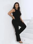 Black sleeveless jumpsuit with drawstring waist, angled front view against white wall.