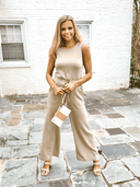 Tan sleeveless jumpsuit with wide legs and drawstring waist, front view.