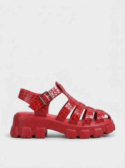 Red crocodile-embossed cage flatform sandal with lug sole and silver buckle ankle strap, side view on white background.