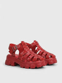 Red cage flatform platform sandal with chunky lug sole and adjustable buckle strap, angled view on white background.