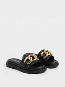 Black flatform mule slide sandal with gold chain centrepiece on the wide toe strap, angled product view.