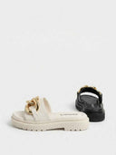 Beige and black chunky gold-chain platform slide sandals side by side on white background, angled view.