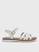 White flat strappy sandals with crisscross straps, elastic ankle band, and brown footbed lining, side product view.