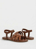 Brown flat open-toe sandals with multi-strap forefoot and gathered elastic ankle band, angled view on white background.