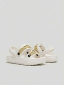 White chunky platform sandals with gold chain strap detail and adjustable ankle clip, angled view showing open round toe and thick flatform outsole.