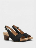 Black platform slingback sandal with cork footbed, wood-look block heel and open peep toe, angled view.