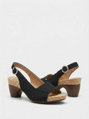 Black cork platform block heel sandal with wide toe band and slingback buckle, front angled view.