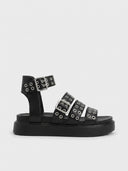 Black chunky flatform sandals with three silver buckle straps, metal eyelet grommets throughout, and thick rubber platform sole, side view.