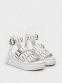 White platform sandals with multiple adjustable buckle straps and silver eyelet trim, angled view highlighting the chunky flatform sole.