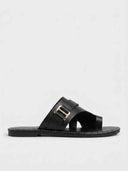 Black cross-strap flat slide sandal with gold-tone rectangular buckle and white contrast stitching, side profile view on white background.