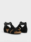 Black matte suede-feel slingback sandals with cork footbed, contoured arch support visible at heel, angled view.