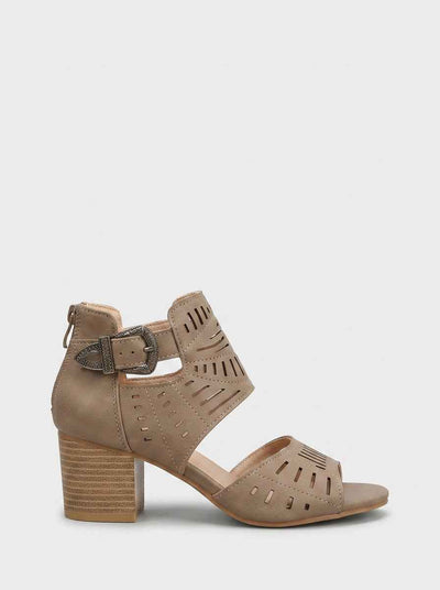 Taupe laser-cut block heel sandal with ornate silver ankle buckle and stacked wooden heel, side view on white background.
