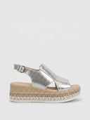 Silver metallic espadrille wedge platform sandals with jute rope sole and stud trim detail, side view on white background.