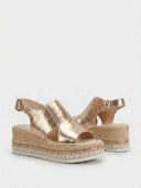 Gold metallic slingback espadrille wedge sandals with braided jute platform and adjustable buckle strap, angled view.