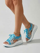 Blue lace-up open-toe platform sandals with grey synthetic overlays and thick white cushioned sole, angled view.