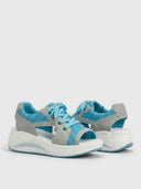 Blue open-toe lace-up platform sandals with blue laces, mesh upper, and white cushioned sole, angled view.
