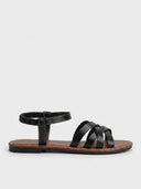 Black flat crisscross strap sandals with elastic ankle band, angled view on white background.