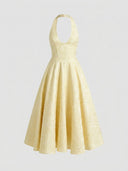Pale yellow halterneck mini dress with textured floral pattern, front view on a light background.