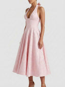 Pink halterneck mini dress with floral jacquard, bow detail, and full skirt, angled view.