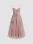 Pink spaghetti strap dress with ruffled bust, corset lacing, and flared tulle skirt, front view.