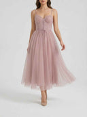 Pink spaghetti strap mini dress with corset bodice and flared tulle skirt, front view.