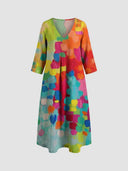 V-neck midi dress with colorful brushstroke pattern, front view on gray background.
