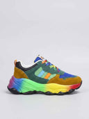 Chunky low-top trainer with multicolour upper panels and rainbow gradient midsole, side view on white background.