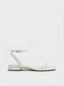 White square-toe strappy sandal with adjustable silver-buckle ankle strap and low block heel, side view on white background.