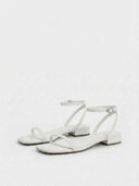 White square-toe strappy sandals with silver-buckle ankle strap and low block heel, angled front view on white background.
