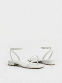 White strappy sandals with adjustable ankle strap and square toe, three-quarter view on white background.