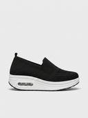 Black slip-on platform knit trainer with thick white air-cushion sole, side view.