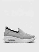 Light grey slip-on platform knit trainer with air-cushion heel window and thick white sole, side view.
