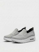 Grey slip-on platform knit walking trainers with white air-cushion sole, angled view on white background.