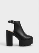 Black closed-toe slingback chunky platform heels with lug sole and silver buckle ankle strap, side view on white background.