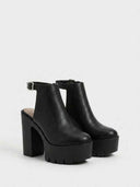 Black closed-toe platform heels with thick lug-sole platform and block heel column, angled view on white background.