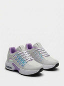 Side profile of chunky lace-up trainers highlighting the stacked white air-bubble midsole and black rubber outsole with purple midsole plug accent.