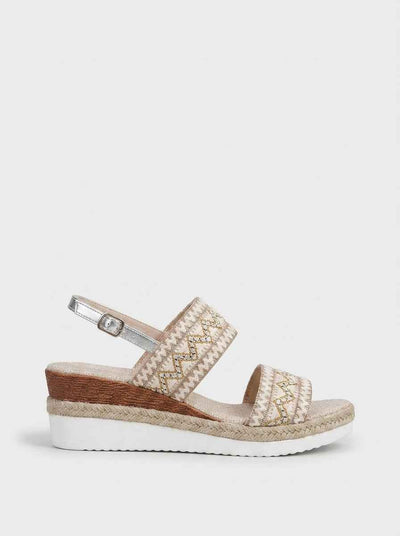 Beige embroidered espadrille wedge sandal with geometric zigzag wide strap, silver slingback buckle, and rope-jute trim sole, side view.