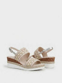 Pair of beige wedge sandals with embroidered wide toe strap and espadrille rope sole trim, angled view on white background.