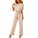 Beige round neck jumpsuit with short sleeves and waist tie, front view.