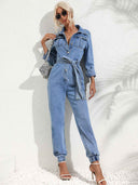 Light blue denim jumpsuit with flap pockets, front buttons, and tie waist, front view.