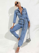 Light blue denim jumpsuit with flap pockets, front buttons, and tie waist, angled front view.