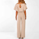 Beige jumpsuit with short sleeves and keyhole back, rear view on white background.