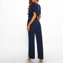 Navy blue jumpsuit with short sleeves and tie waist, back angled view.