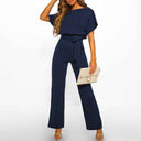 Navy blue short-sleeve jumpsuit with tie waist and wide legs, front view on white background.