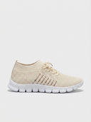 Beige mesh lace-up trainers with white sole and gold tongue branding tag, angled side view on white background.