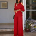 Red cold-shoulder jumpsuit with V-neck and wide legs, front view.