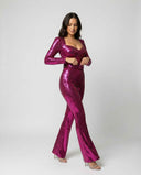 Fuchsia sequin jumpsuit with sweetheart neckline, long sleeves, and flared legs, angled front view.